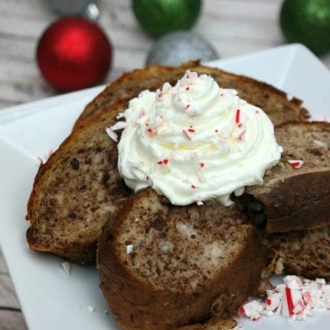 Candy cane French Toast on a white plate with Christmas balls.