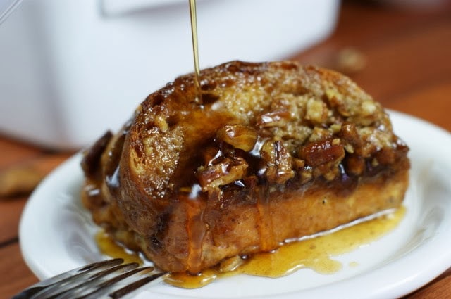 French toast on a white plate with syrup.