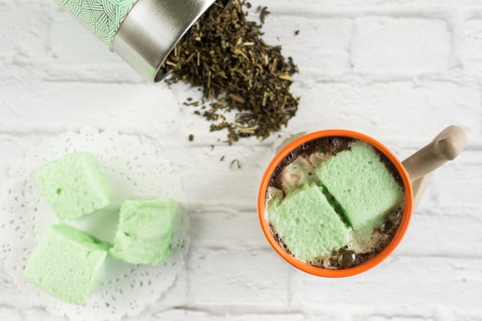 Green marshmallows in a bowl with mint tea.