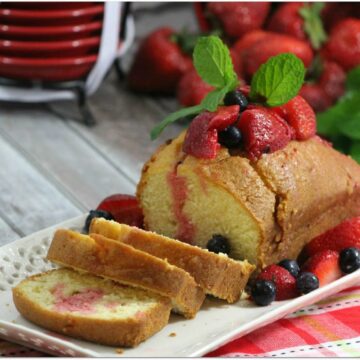 Loaf of pound cake with berries and mint.