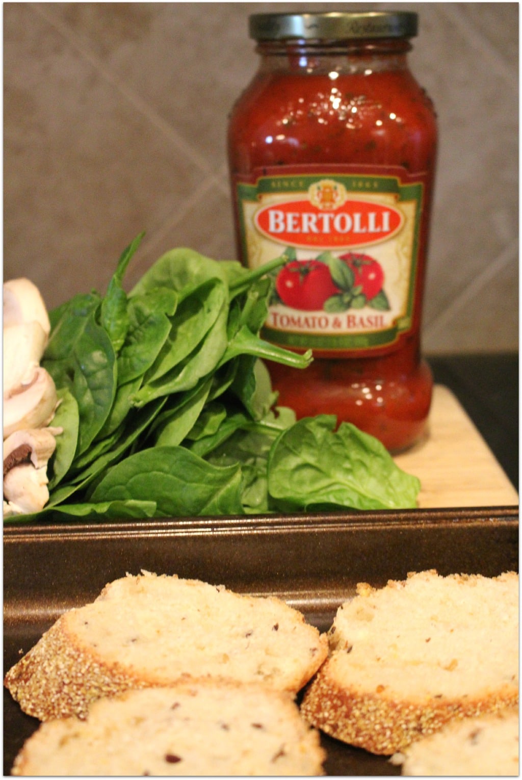 Spinach and mushrooms with a jar of sauce.