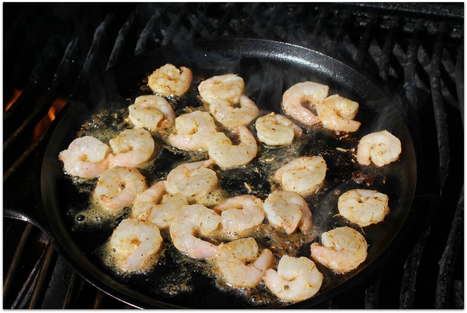 Shrimp in cast iron skillet on grill.