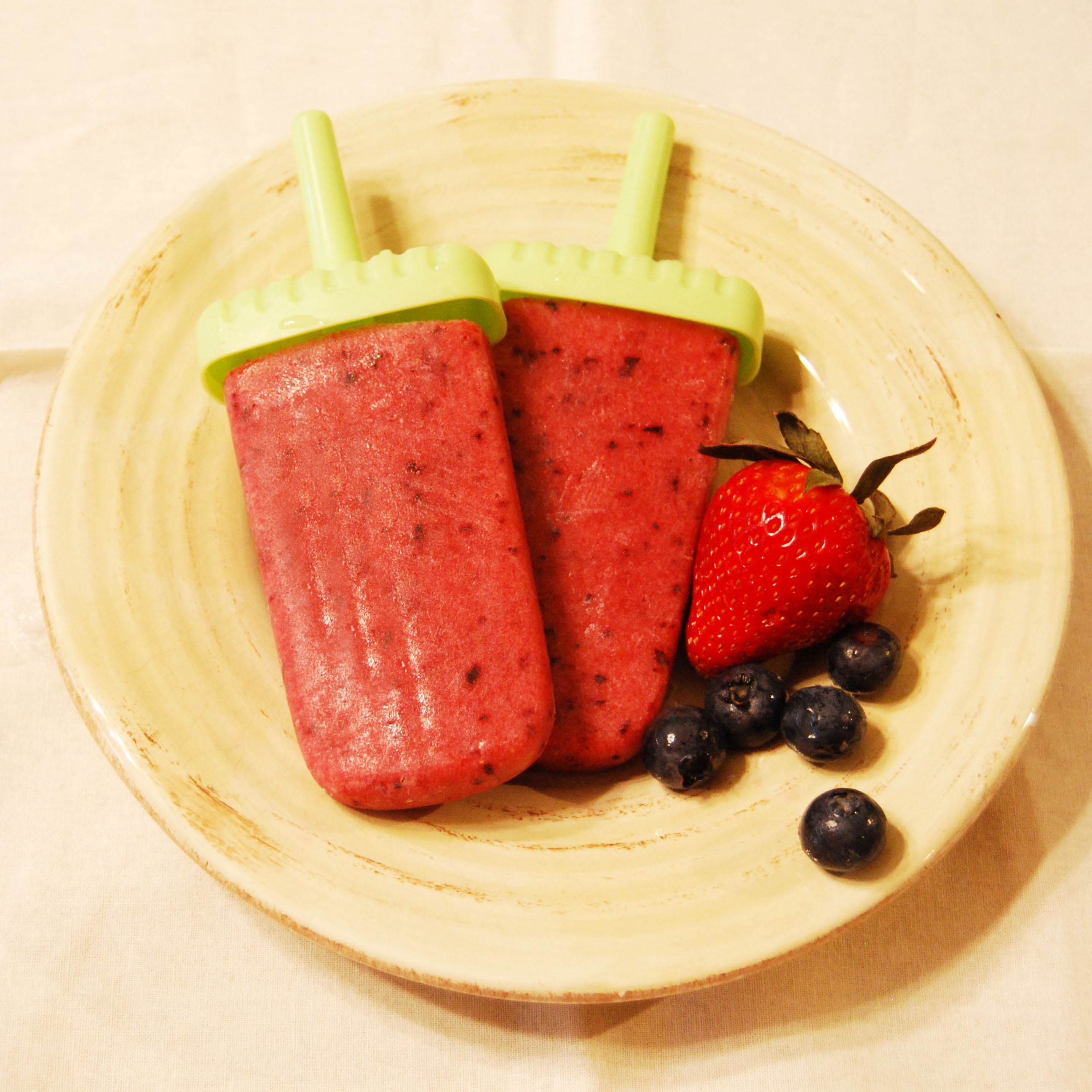 These Healthy Strawberry Apple Ice Pops are the perfect treat any time of day! This recipe is made with only fruit and no added sugar, and is a healthier alternative to Popsicles and ice cream, perfect for those of us who are trying to trim down for summer swim suits! Strawberries and apples are a yummy combination for this delicious treat, and instead of sugar, we've just added more fruit! This easy recipe will have you in and out of the kitchen in minutes, and you will love the flavor of this icy treat!