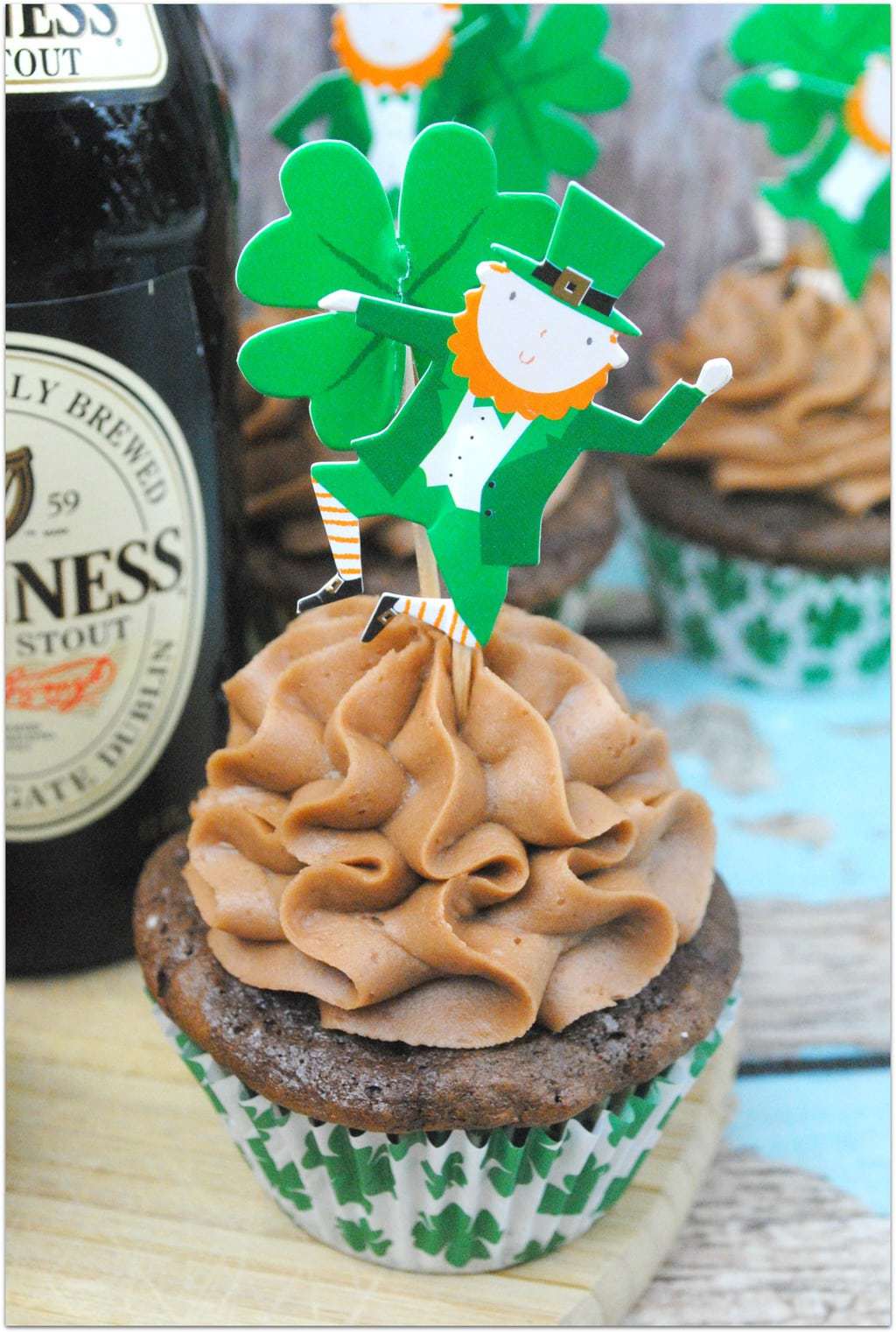 Chocolate cupcakes with chocolate icing wtih an Irish dancer on top.