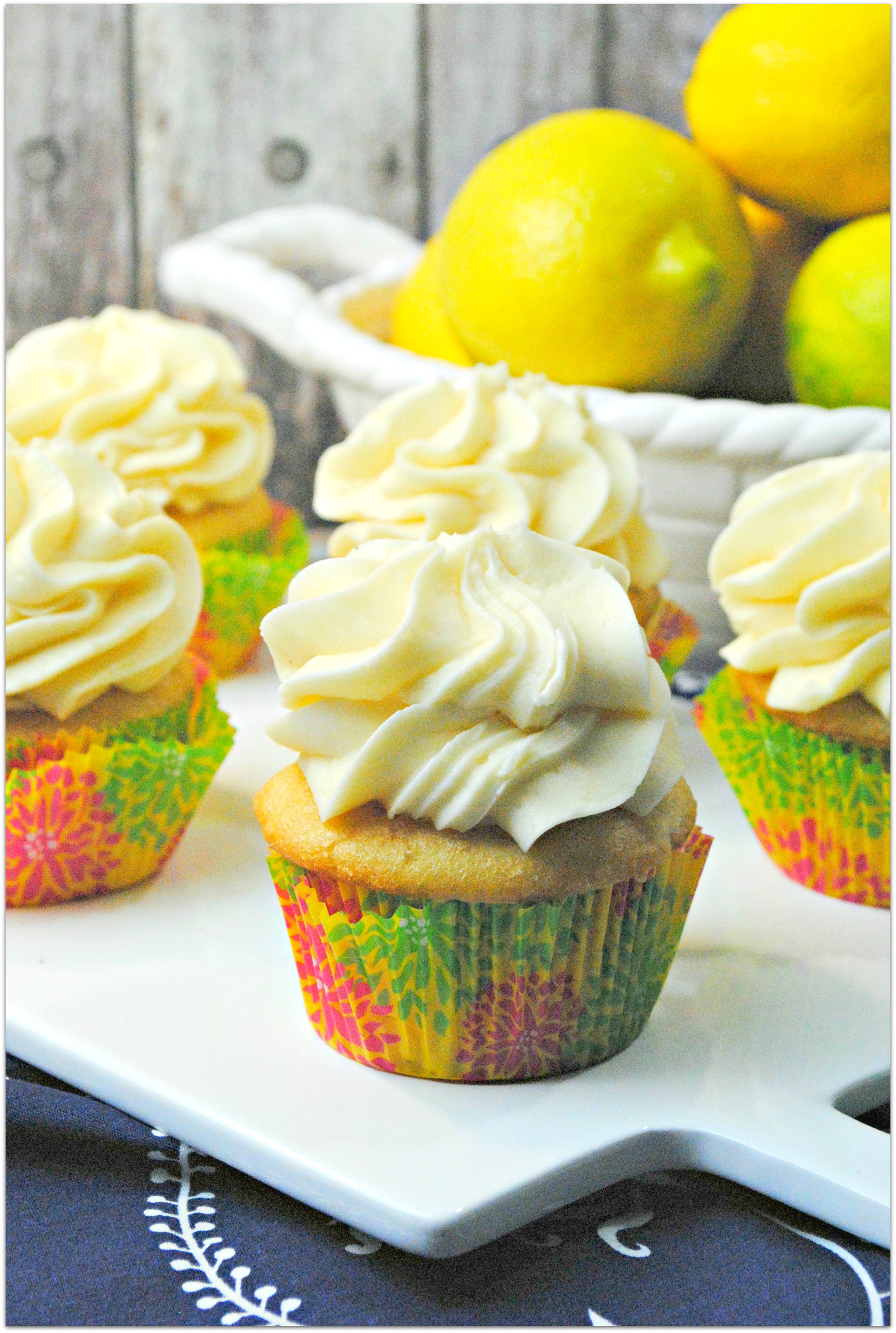 Lemon cupcakes on white platter.