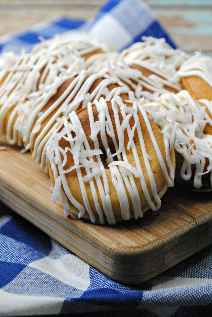 Doughnuts with crazy flavors are all the rage, and these Pineapple Doughnuts are the perfect easy recipe for a lazy weekend! Made with real pineapple and coconut, your family will love the tropical flavors.