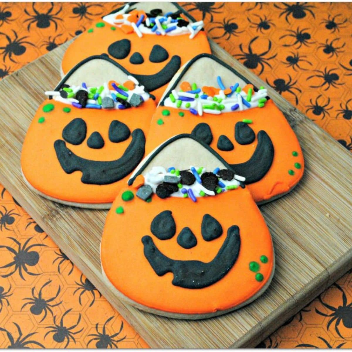 Orange iced cookies in the shape and decorated like candy corn.