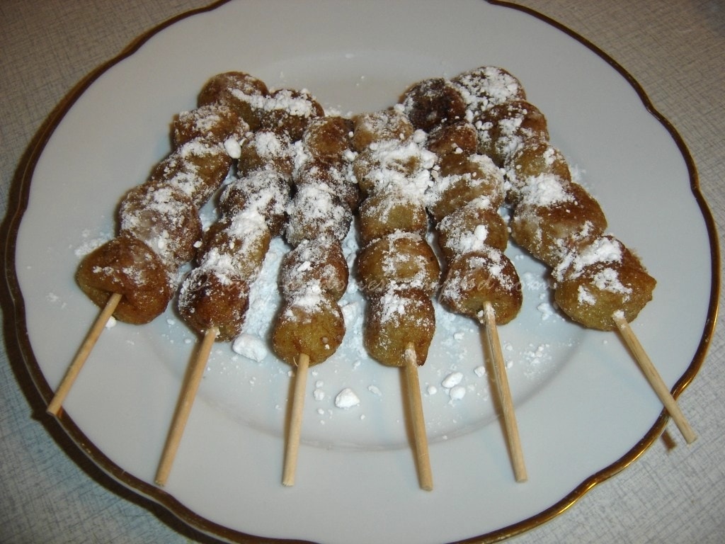 Indonesian street food sticks on a white plate.