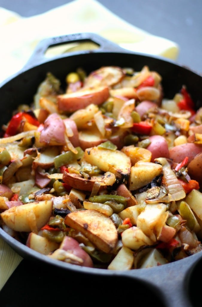 Potatoes with onions and peppers in a skillet.