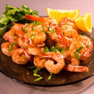 Cooked Shrimp on a plate with lemon slices.