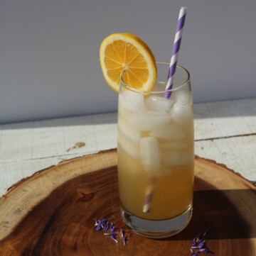Glass of lemonade on a wood wood cutting board.