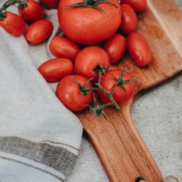 tomatoes on chopping board with towel