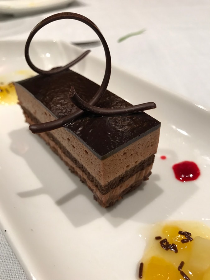 Slice of chocolate cake on a white plate.