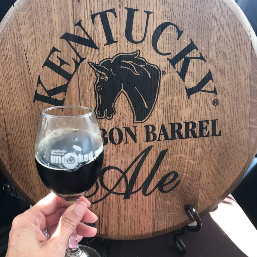 Glass of dark beer in front of barrel at Clearwater Beach Uncorked Wine Festival.