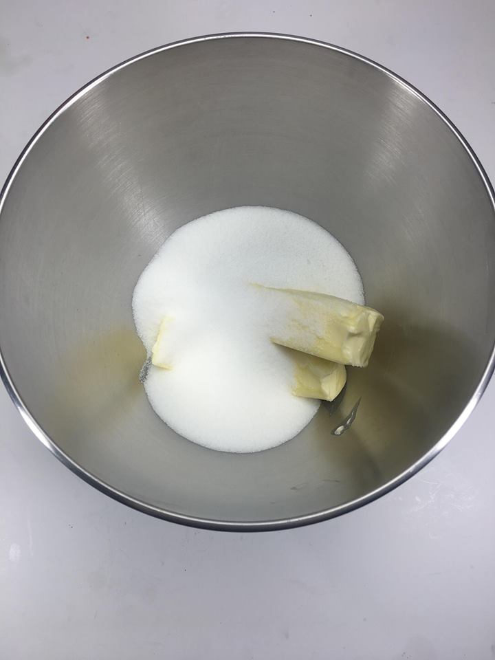 Butter and sugar in a stainless bowl.