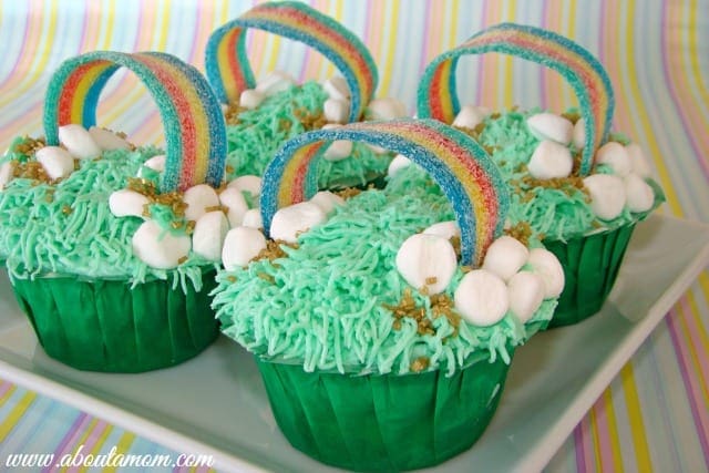 Cupcakes with green frosting and a candy rainbow.
