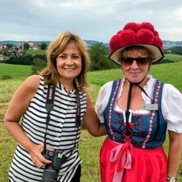 A woman in striped top and a woman in traditional German clothing.