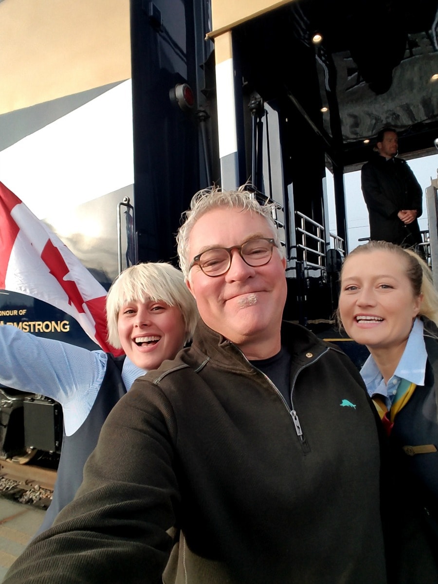 Man with Rocky Mountaineer Train staff with train in background.