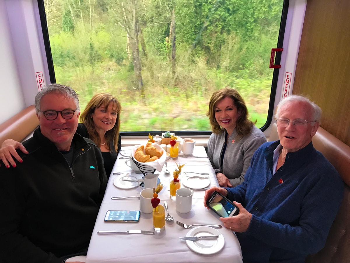 Two couples seated in dining room on Rocky Mountaineer Train. 