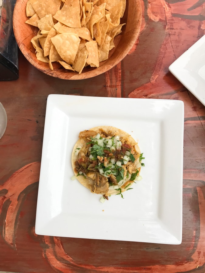 Taco and chips on a wood table.