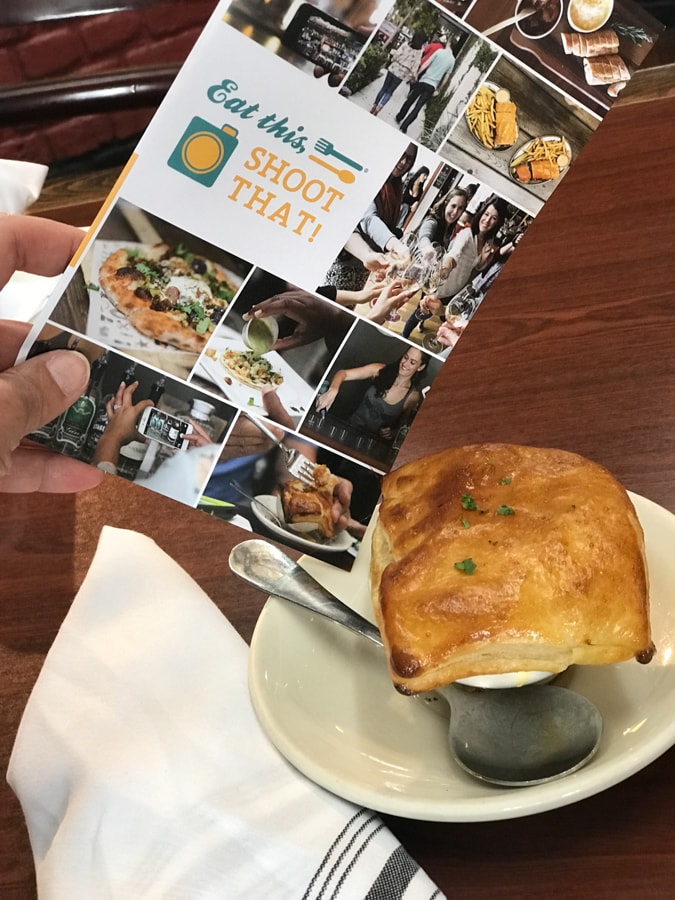 Pot pie on saucer with a spoon and brochure.