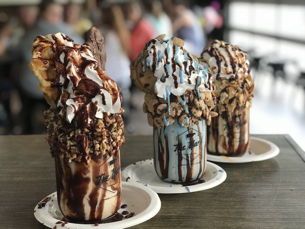 Three milkshakes on wood table at The Yard in Panama City Beach, Florida.