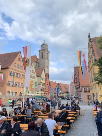 People sitting at tables outside at a festival in Dinkelsbühl.