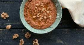 Red pepper drip in a blue bowl with pita.