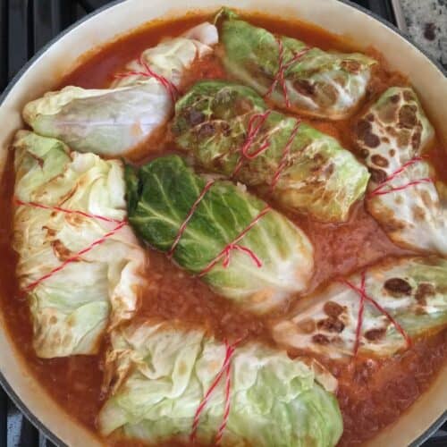 German cabbage rolls in pot with red broth.
