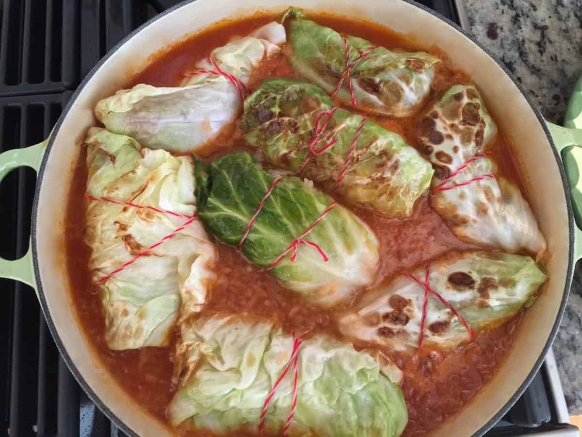 German cabbage rolls in pot with red broth.