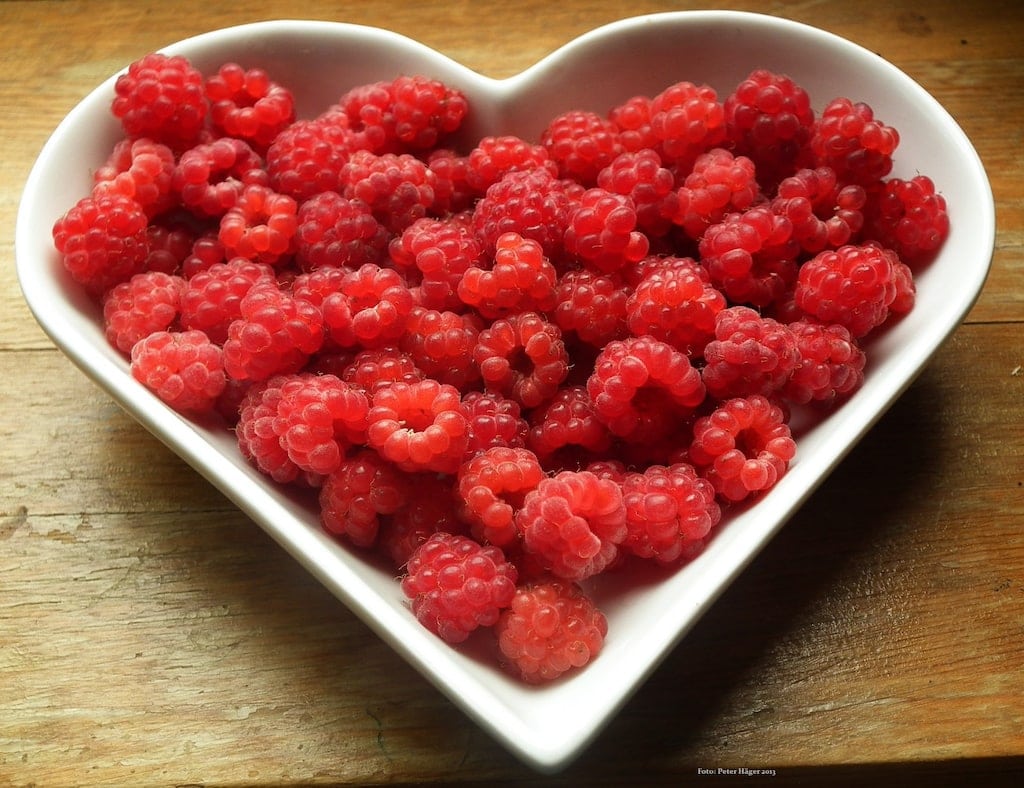 Raspberries in heart shaped bowl.