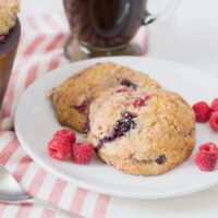 Mixed berry scones on white plate on red and white striped tablecloth