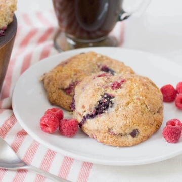 Mixed berry scones on white plate on red and white striped tablecloth