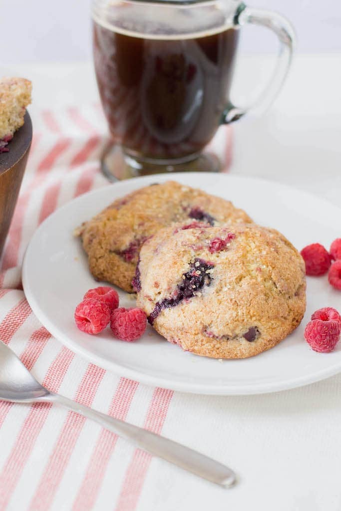 Mixed berry scones on white plate on red and white striped tablecloth