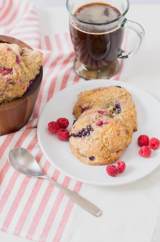 Mixed berry scones on white plate on red and white striped tablecloth