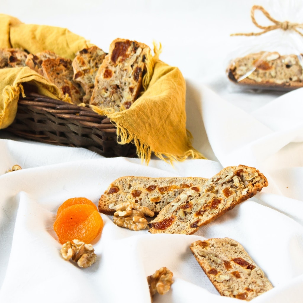 biscotti cookies on a white tablecloth with basketful in background