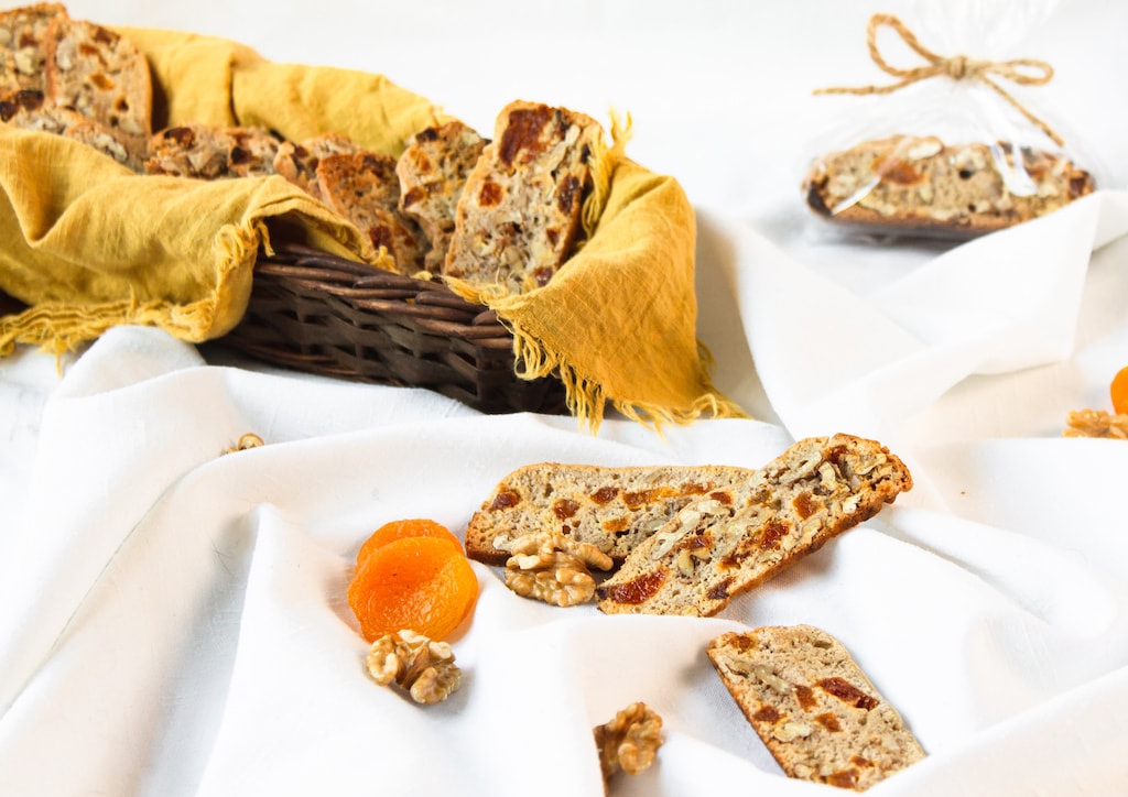 biscotti in a basket with yellow cloth and plastic wrapped with a bow in backgroun