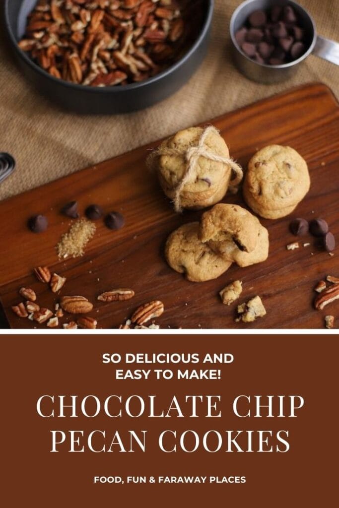 chocolate chip pecan cookies on wood board with chocolate chips and pecan on background