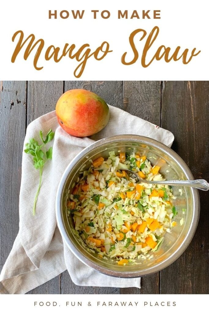 mango slaw in silver bowl with white napkin and mango