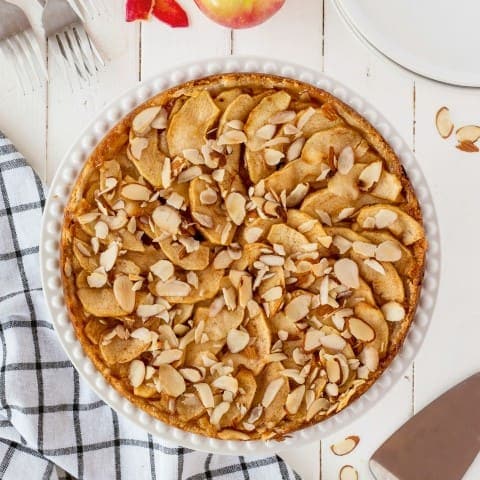 apple torte on a white table with a checked napkin