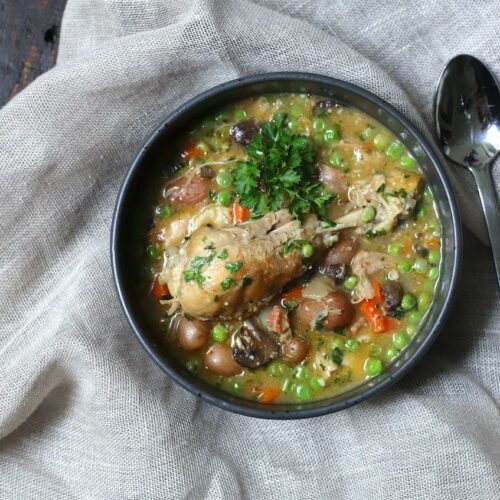 chicken stew in a black bowl on a burlap napkin