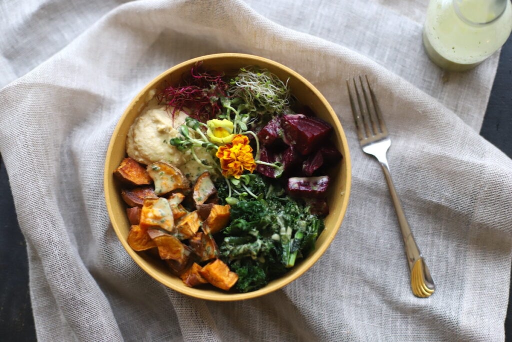 kale and sweet potato vegan power bowl in yellow bowl
