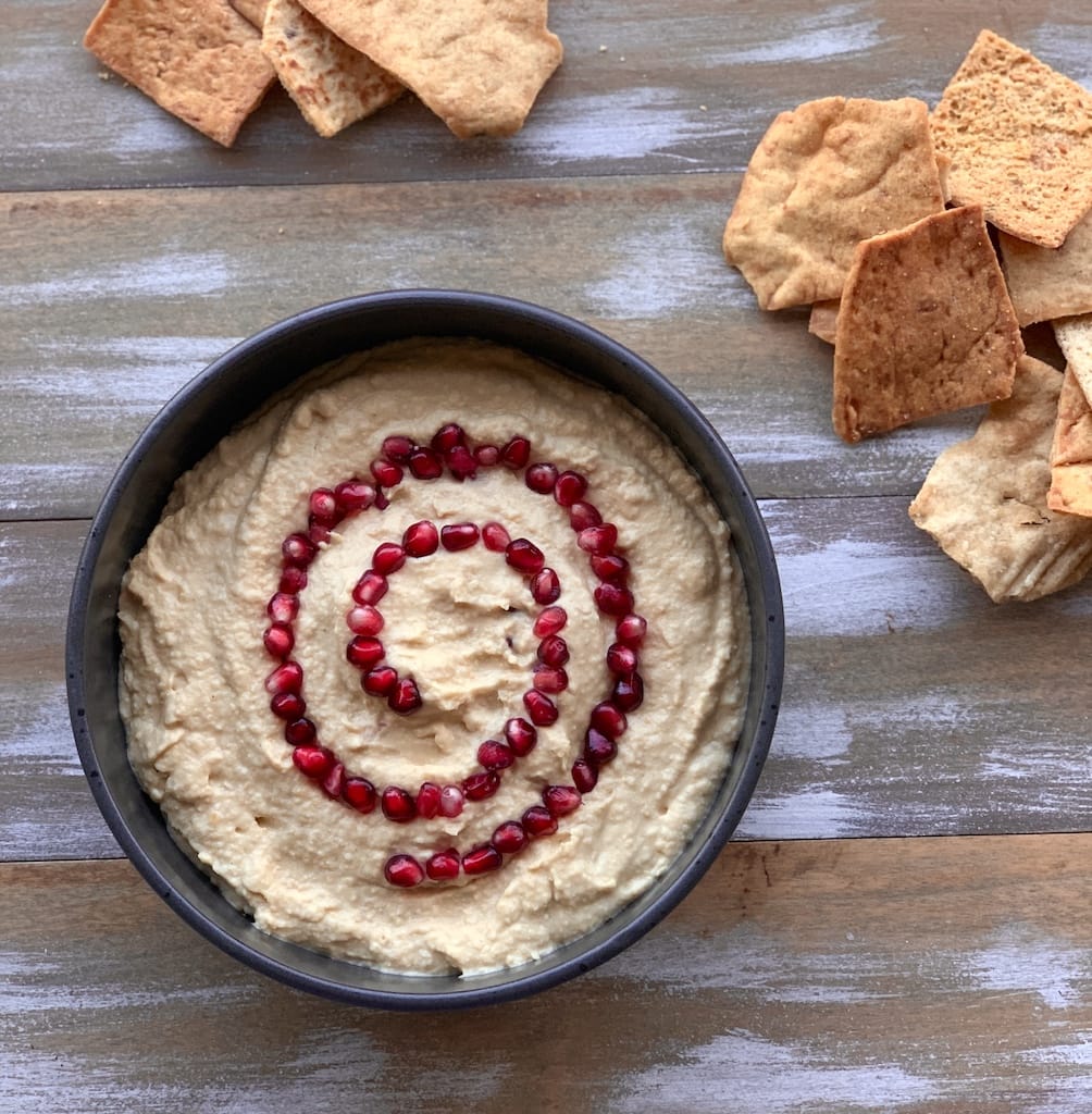 hummus in black bowl with chips