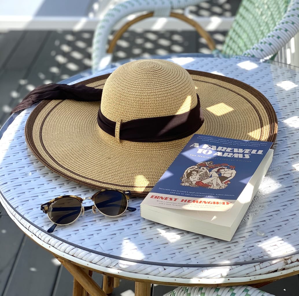 Hat on table with book by pool