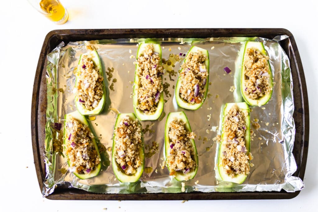stuffed zucchini on foil on baking sheet