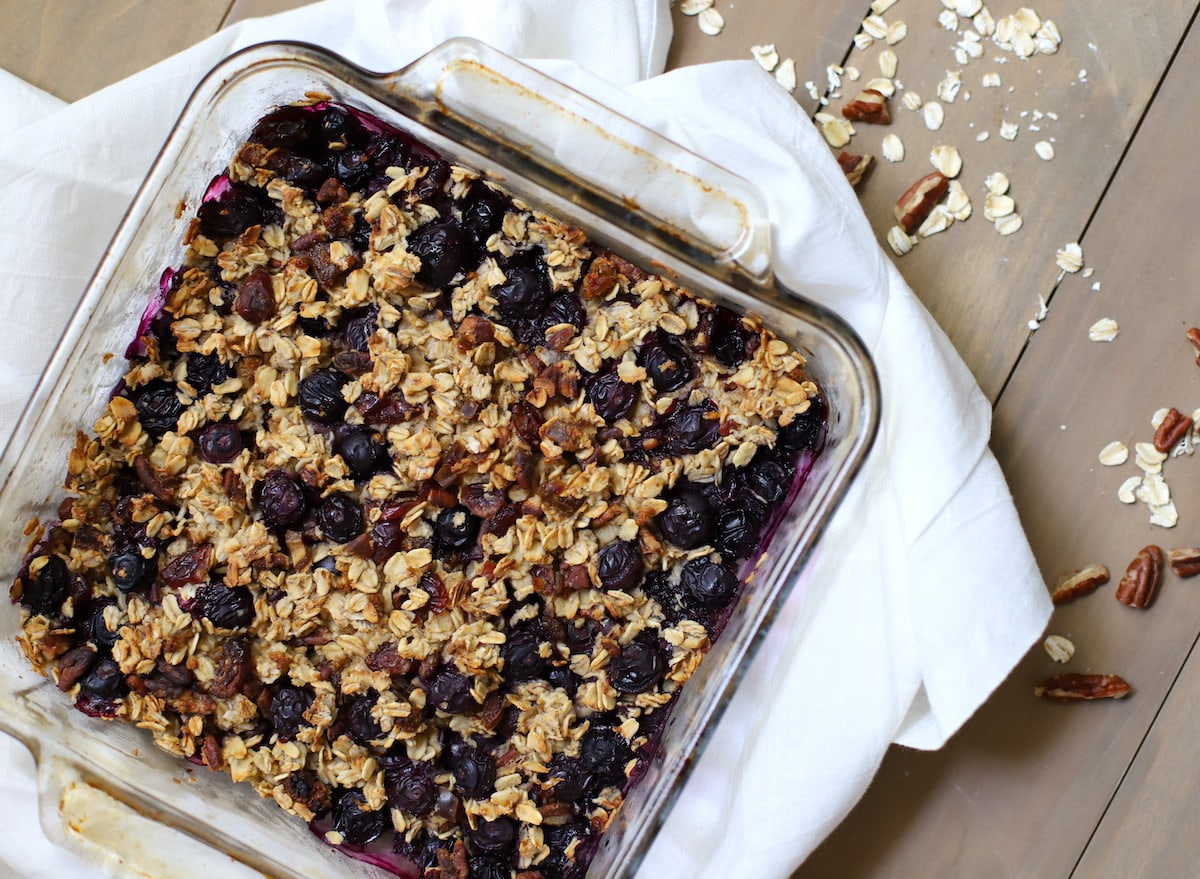 Baked oatmeal with blueberries in a glass dish on a white napkin.