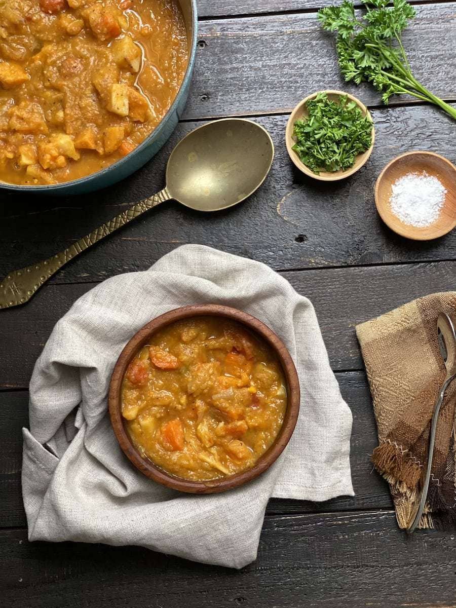 roasted vegetable soup on a black table with a napkin