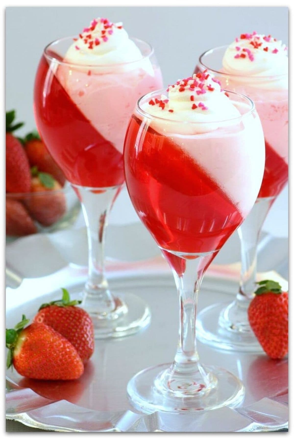 Red jello parfait with whipped cream in tall glasses. 