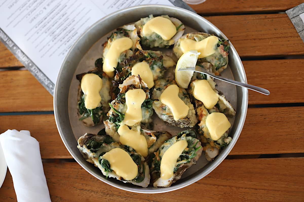 Oyster Rockefeller on a trat on a wood table.