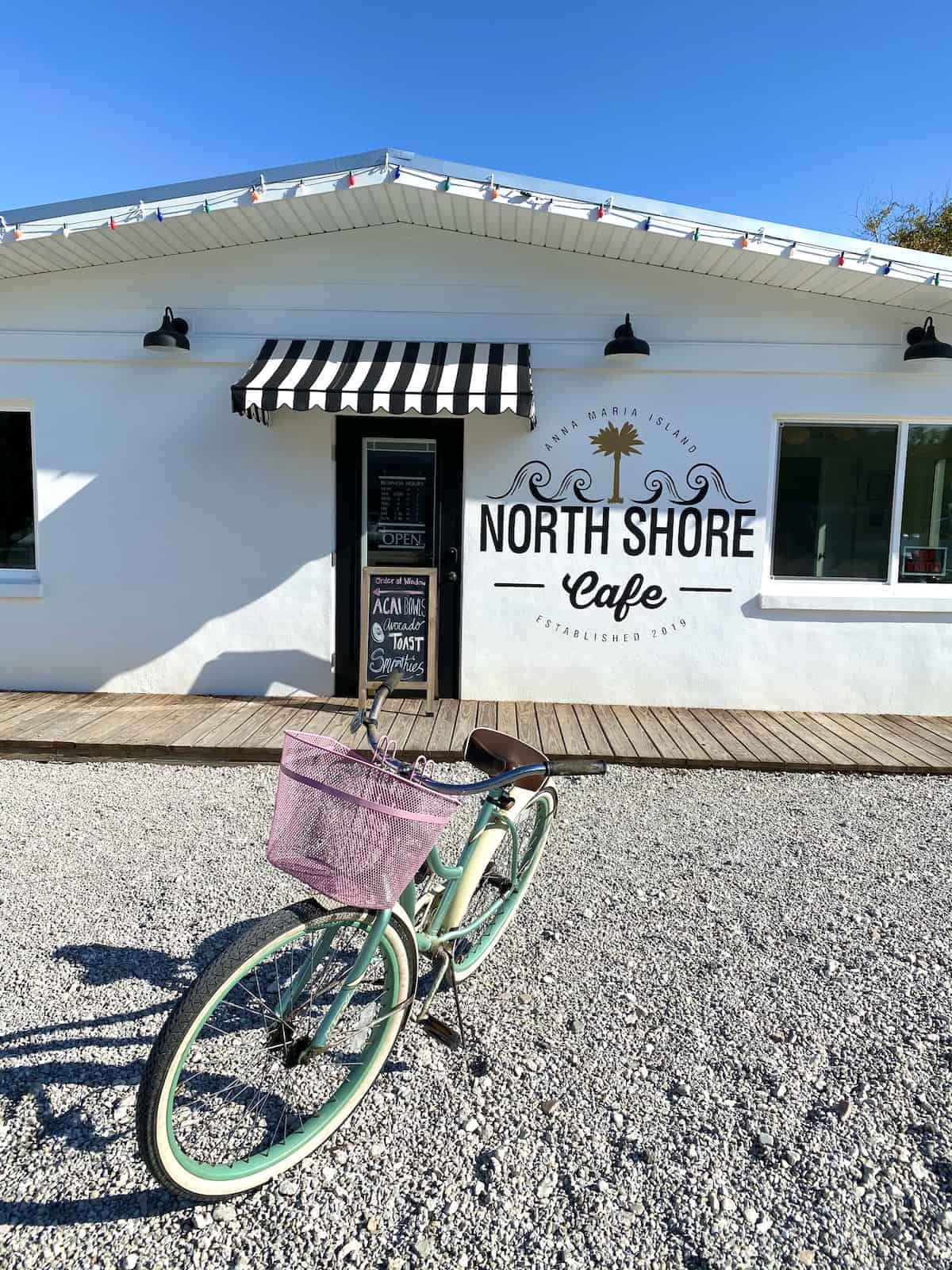 Front of North Shore Cafe with bicycle in parking lot.